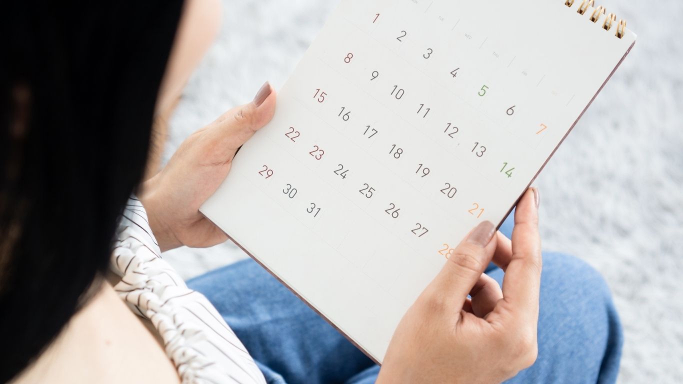 I have a late period, could be pregnant. A woman holding a calendar.