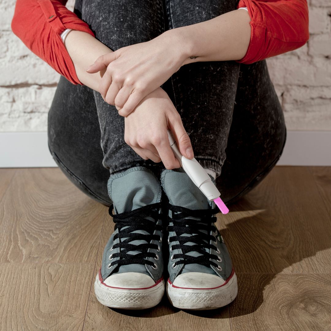 A woman holding a positive pregnancy test.